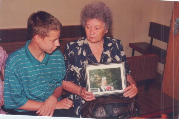 Выживший после нападения маньяка Сергей с мамой и портретом погибшей сестры